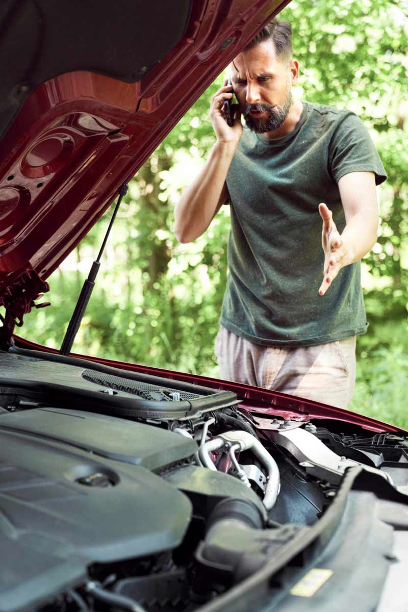 Junger Mann prüft Getriebeschaden bei Schrottauto Ankauf Solingen